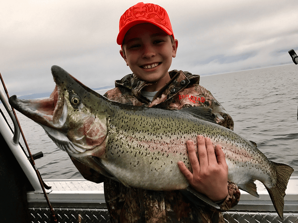 successful fishing trip in Lake Pend Oreille. Child holding fish.